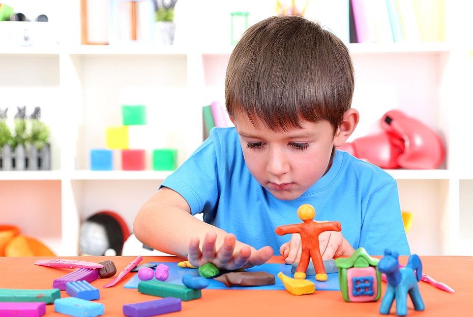 Child happily sculpting colorful clay and craft materials